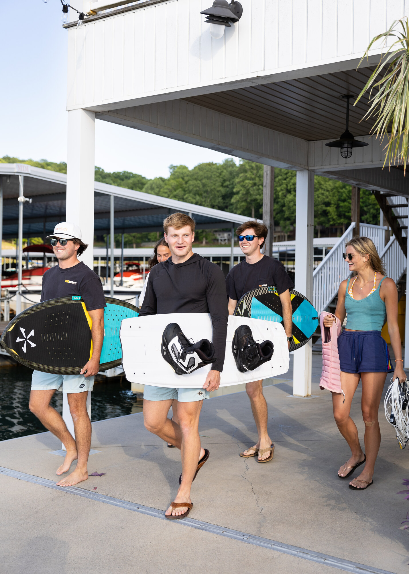 Friends carrying wakesurf boards along the Norris Lake marina dock