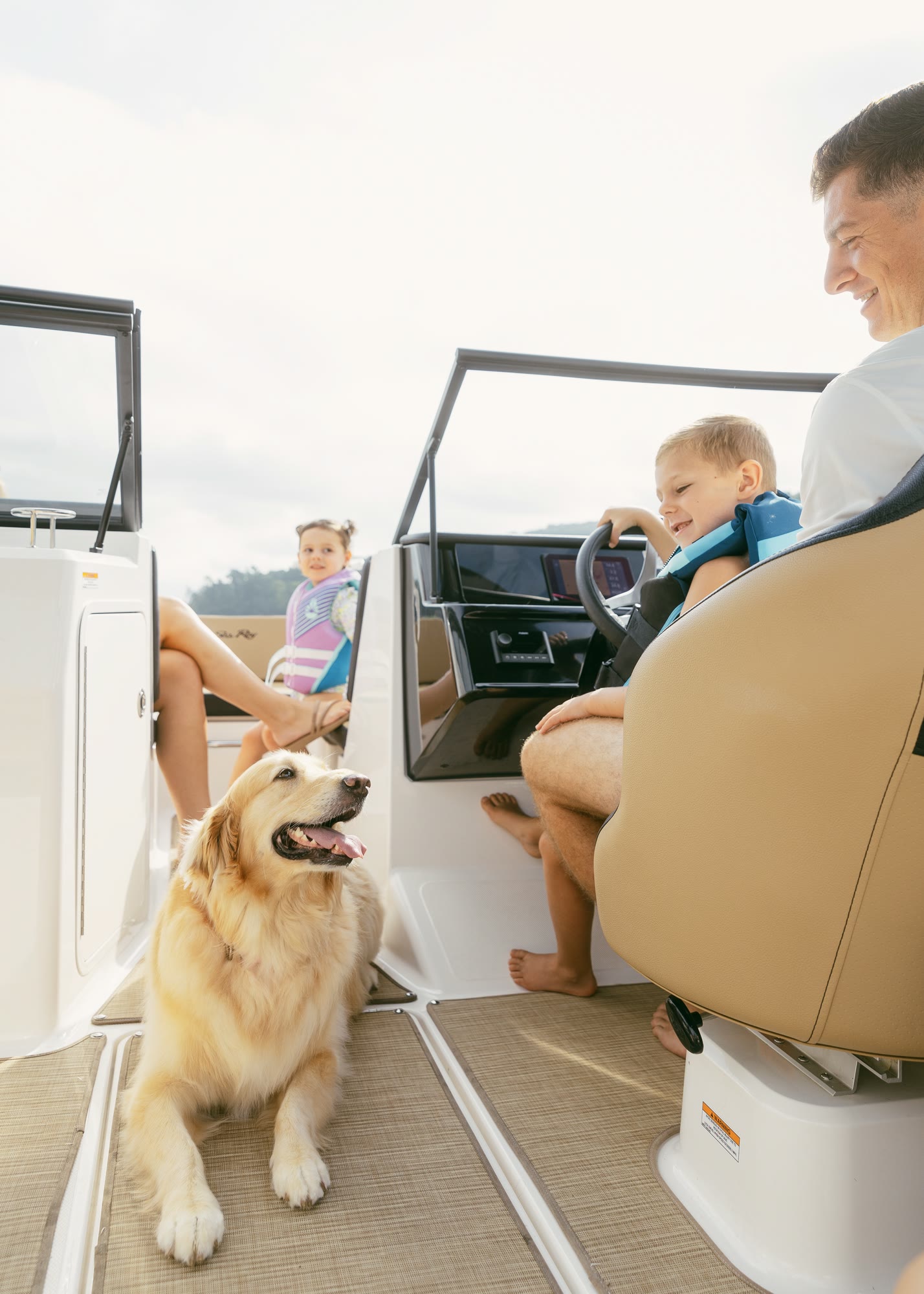 A golden retriever aboard a boat with a father and children