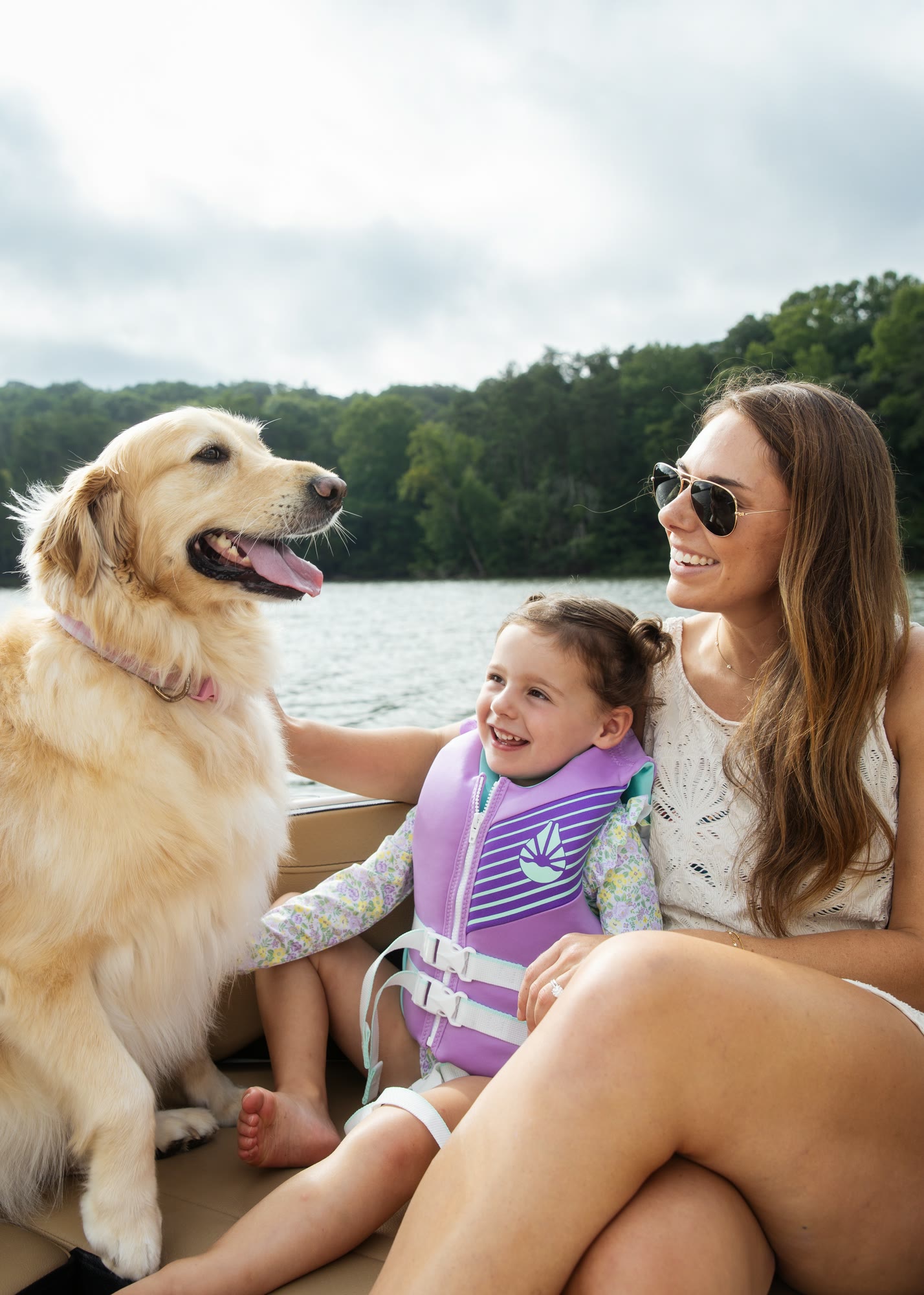 A golden retriever with a mother and child aboard a boat