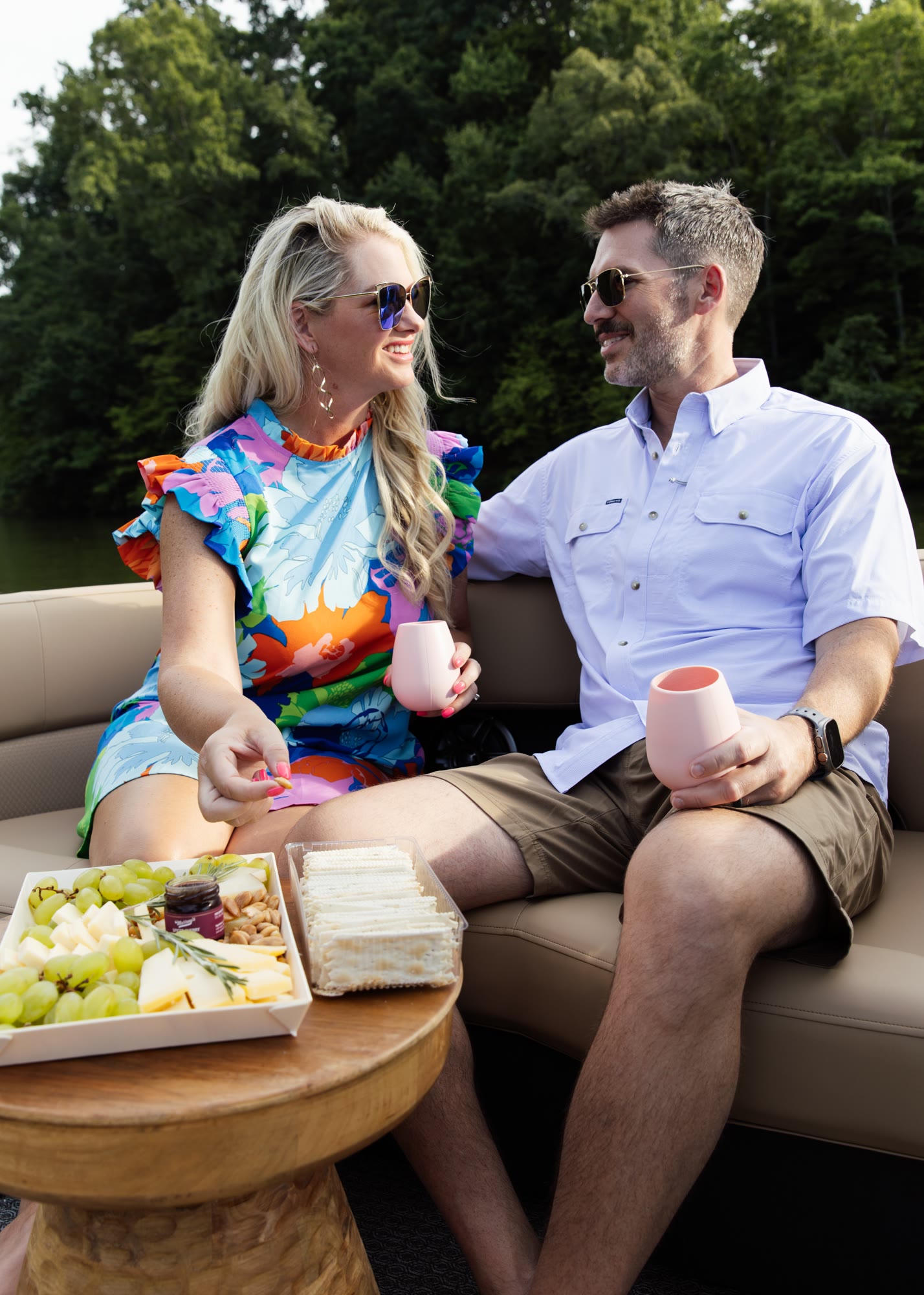 A couple relaxing together with drinks aboard a boat at a covered marina slip
