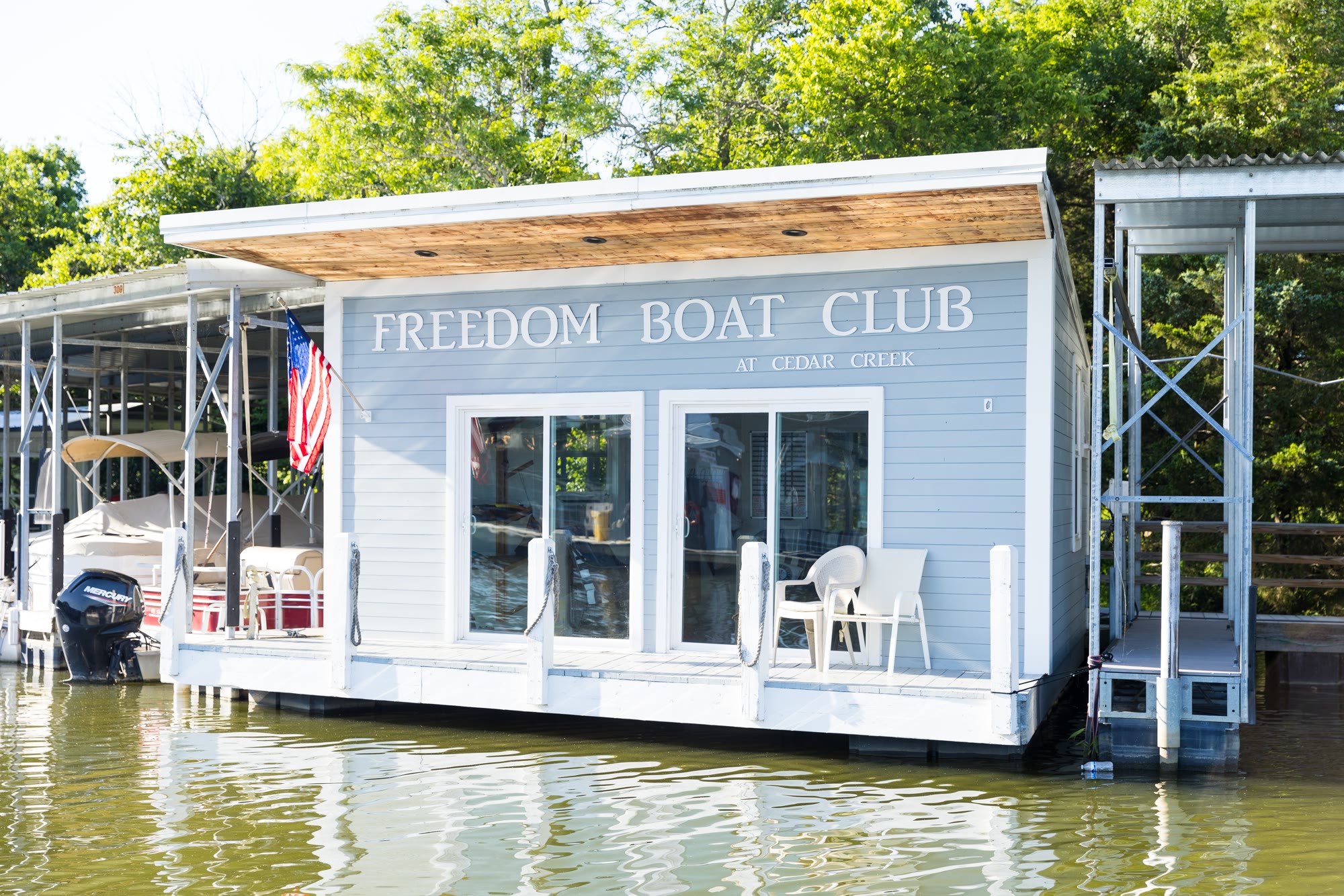 The Freedom Boat Club floating office and club sign at the Cedar Creek marina