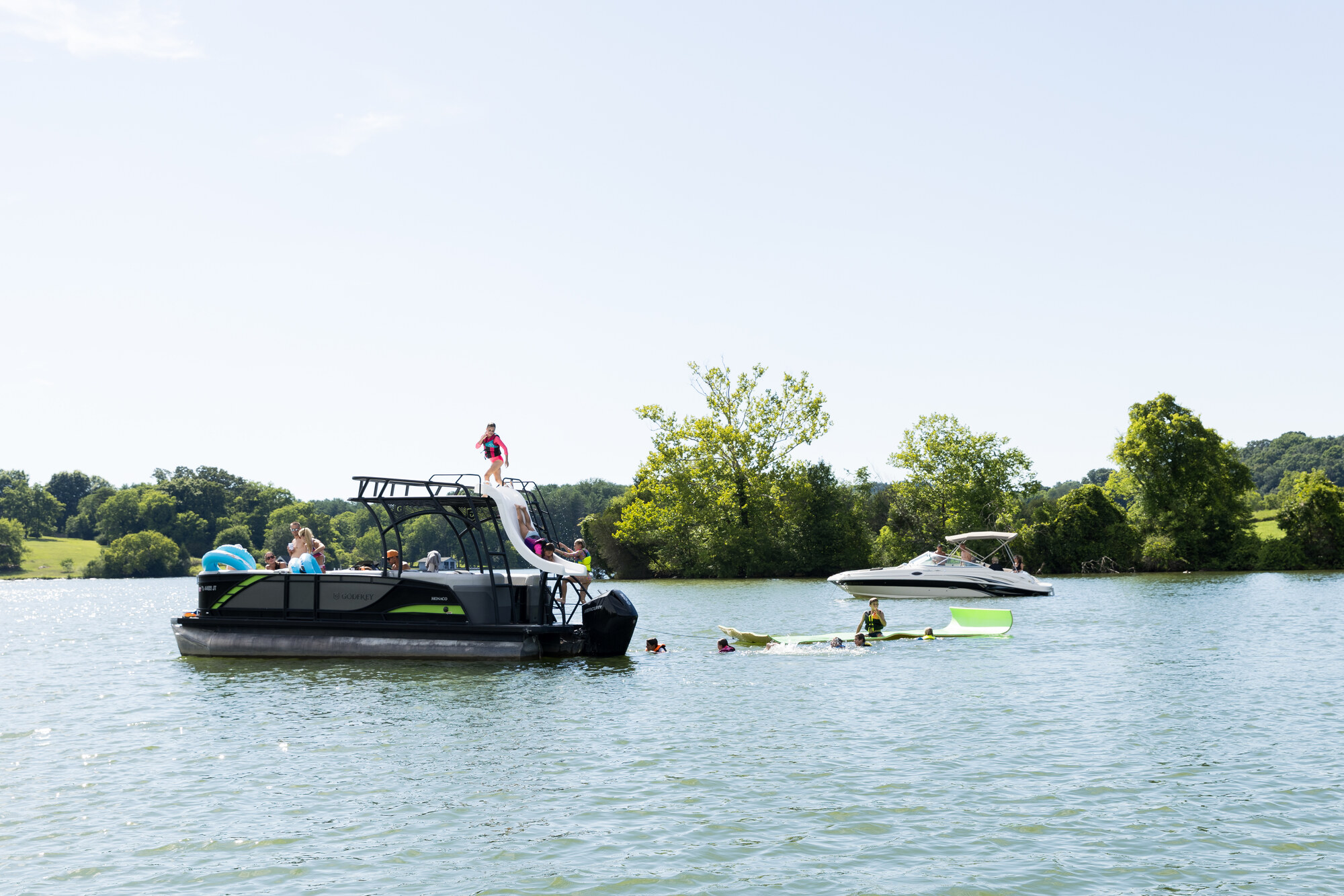 Friends enjoying a swim day beside a Freedom boat on Fort Loudoun Lake
