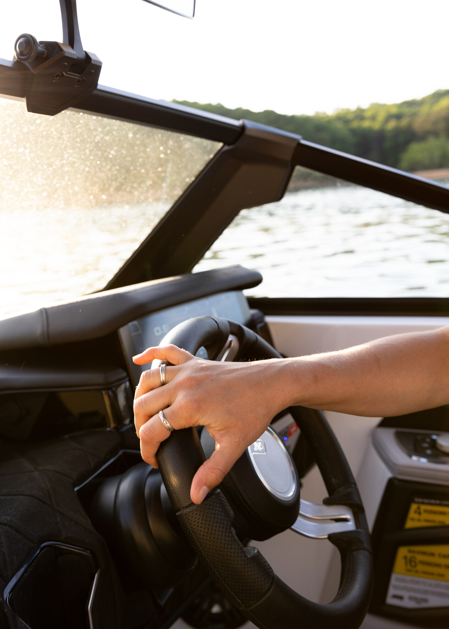 A hand advancing the throttle of a club boat under way