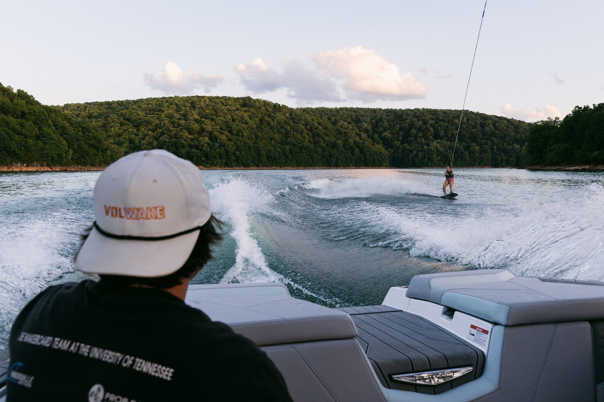A wakesurfer riding behind a club boat on Norris Lake